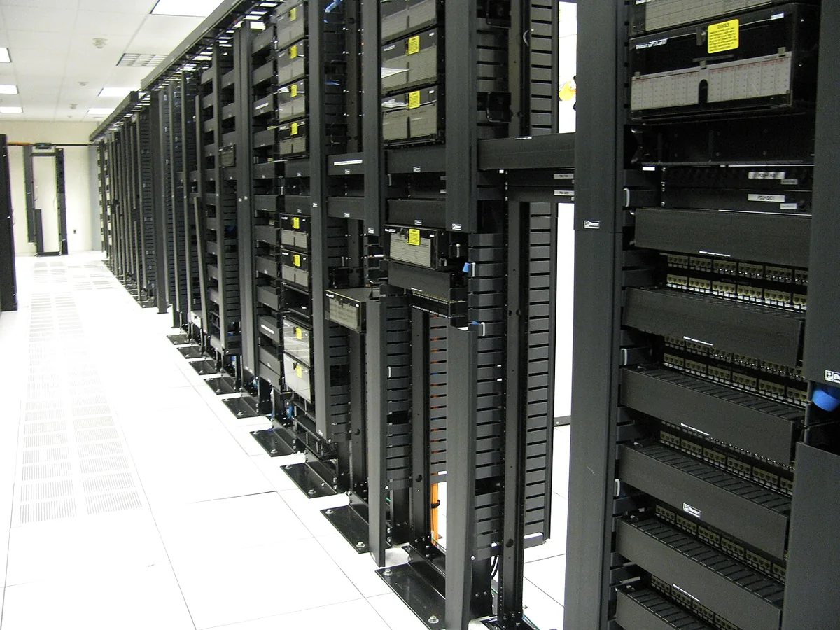A row of server and networking cabinets in a data center aisle