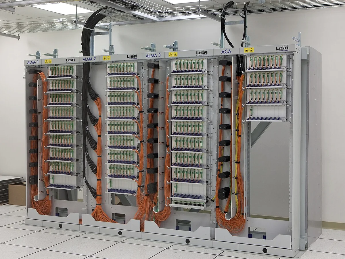 Fiber-optic patch panels with organized orange cabling and overhead cable trays